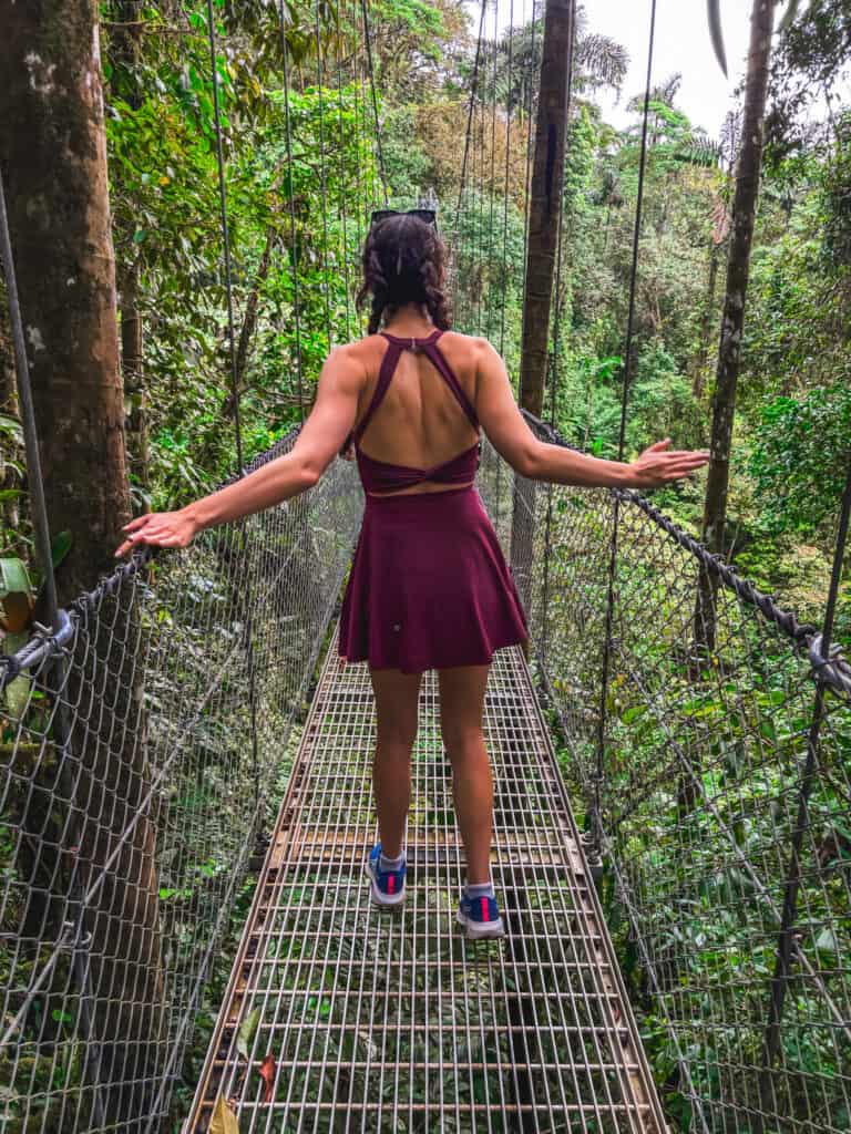 woman crossing mistico arenal hanging bridges