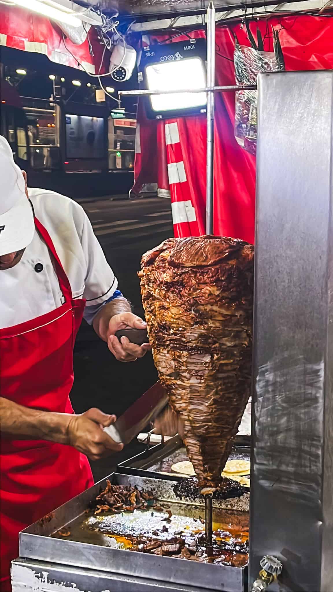 al pastor meat and chef cutting it