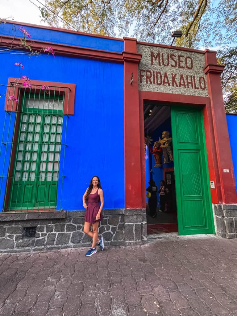 Front entrance of the Frida Kahlo Museum (Museo Frida Kahlo) in Coyoacán, with green doors and bold signage above.