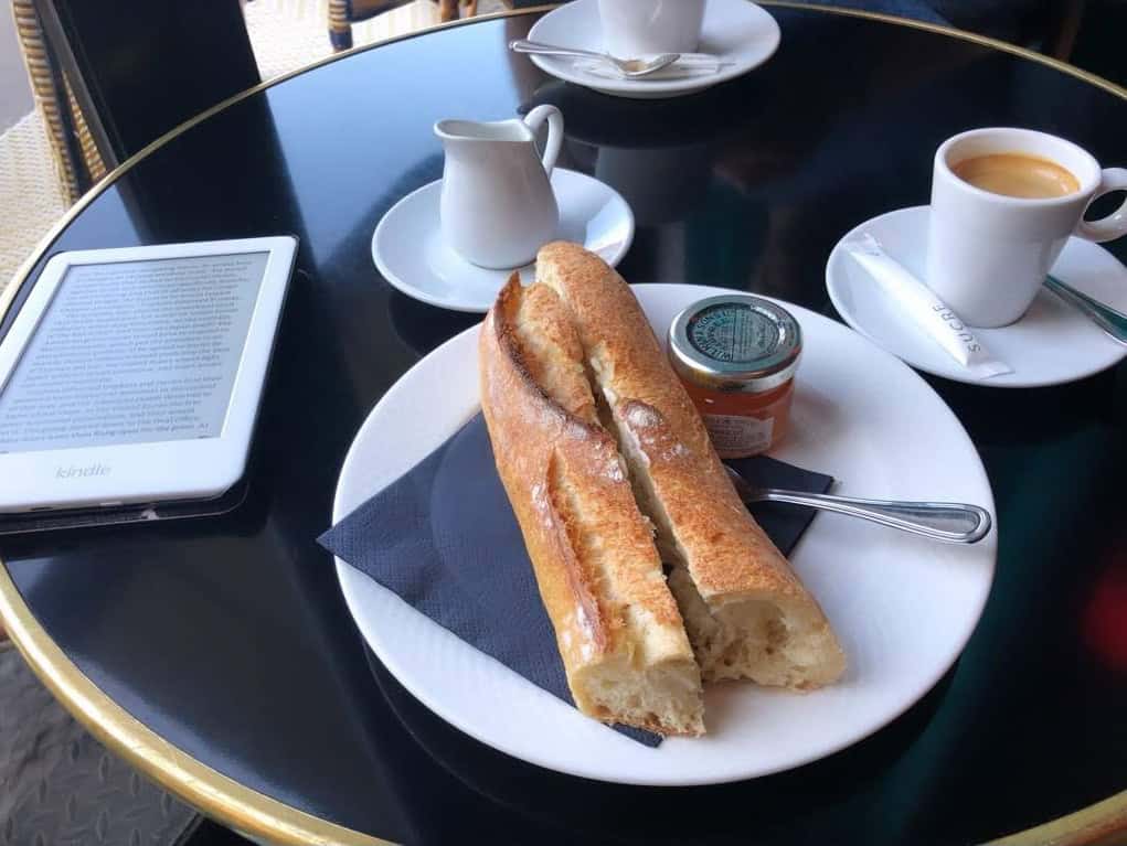 bread and a kindle at a coffee shop in paris