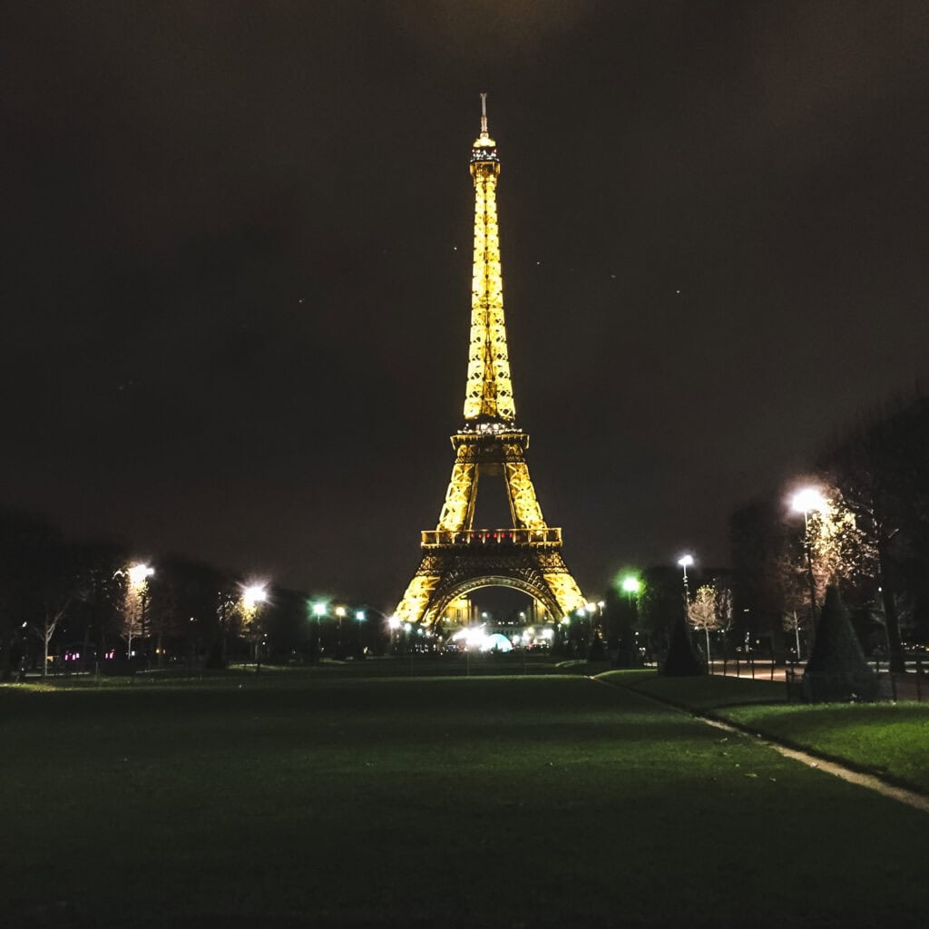 The Eiffel Tower illuminated against the night sky, glowing during a peaceful Paris in winter evening.