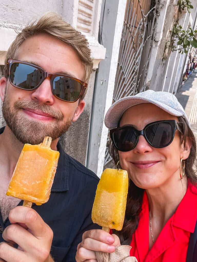 couple eats maracuya popsicles in mexico city