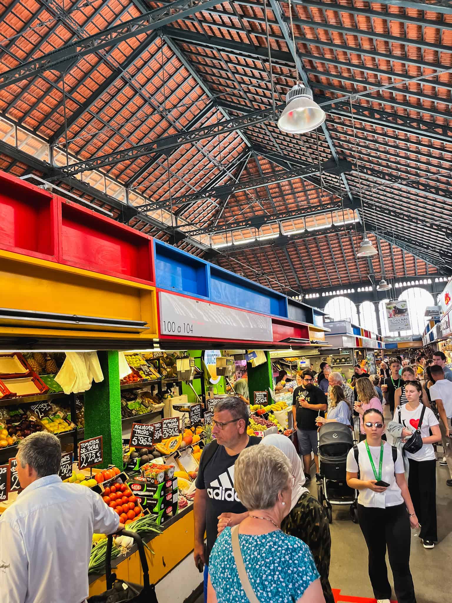 Bustling Atarazanas Market with colorful produce stalls and crowds - top destination for where to eat in Malaga