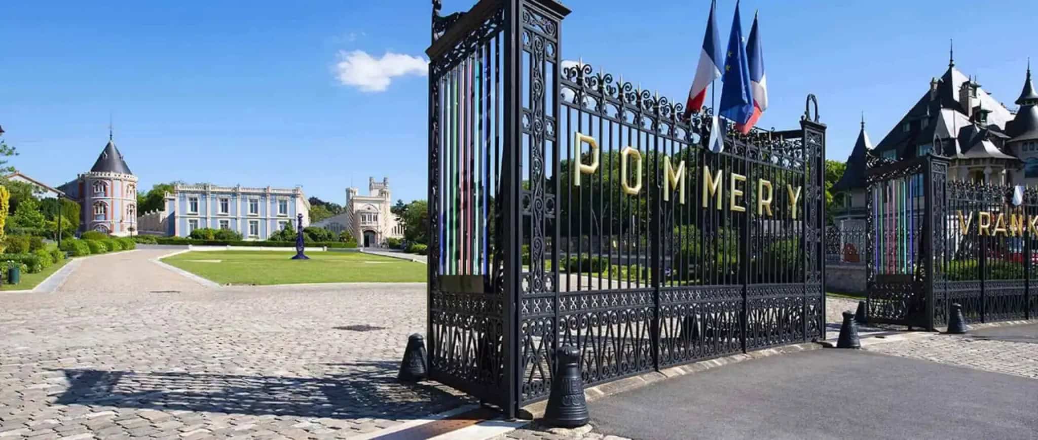 Pommery champagne house entrance gates in Reims with ornate ironwork and French flags