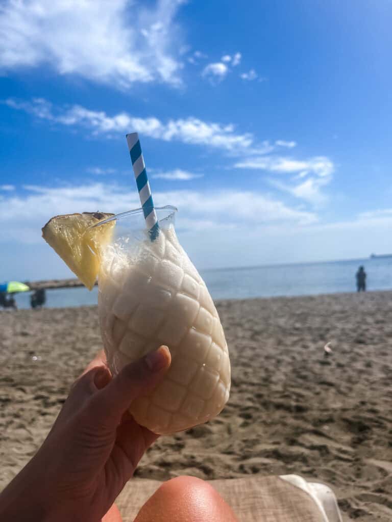 Refreshing pina colada on the best beach in malaga, perfect example of what to do in malaga