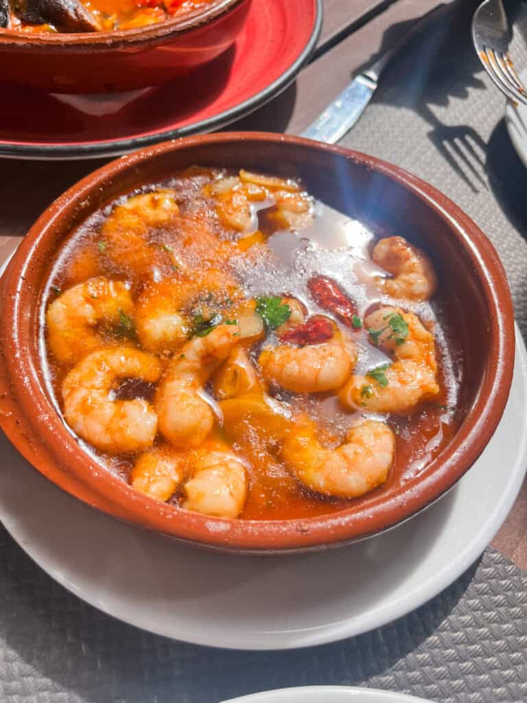 Sizzling garlic shrimp in clay pot, authentic malaga tapas experience