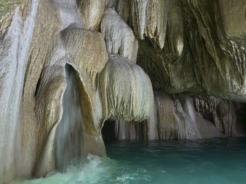 Grutas de Tolantongo cave entrance with turquoise thermal pools and natural waterfalls cascading down limestone walls