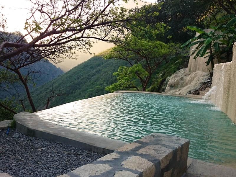 Infinity thermal pool at sunset overlooking the canyon valley with turquoise mineral water