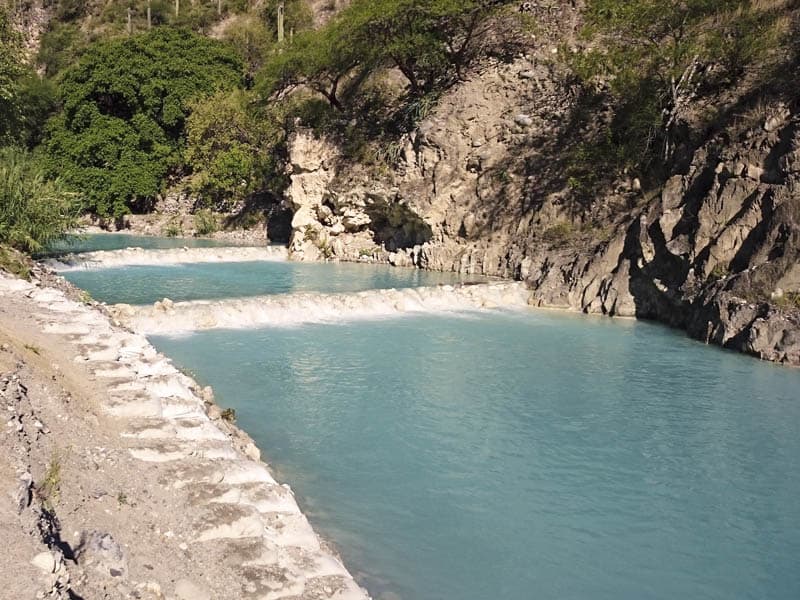 Terraced thermal pools with bright turquoise mineral water carved into the mountainside at Tolantongo