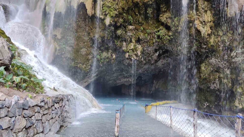 Grutas de Tolantongo cave interior showing limestone mineral formations and turquoise thermal water