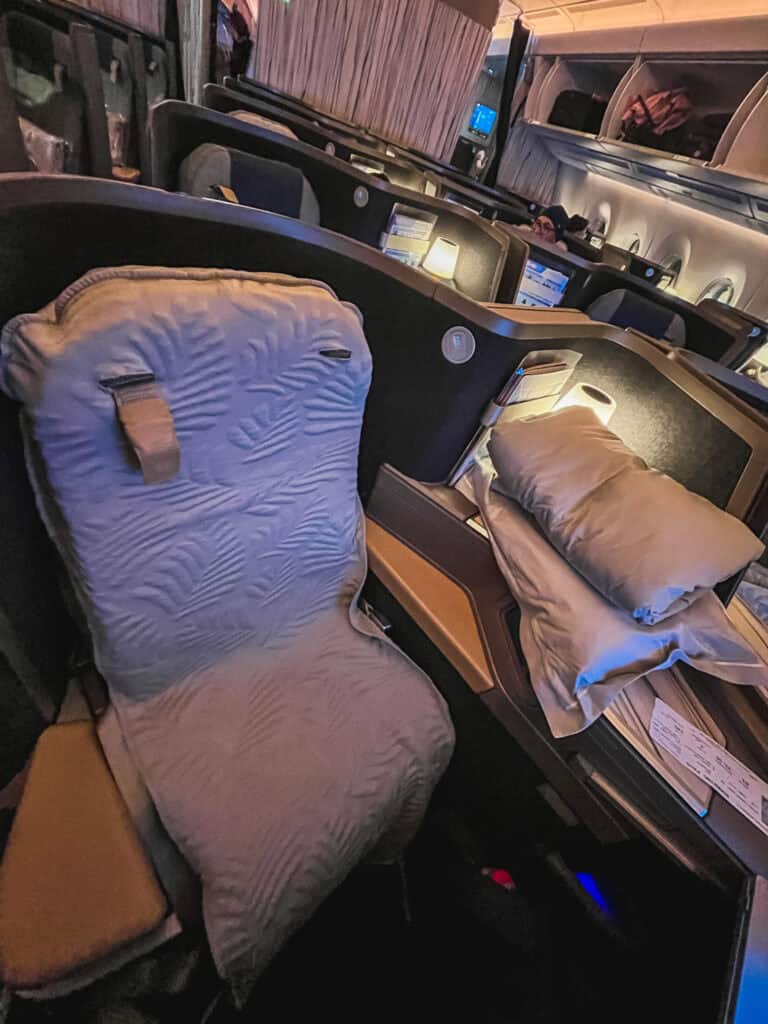 China Airlines business class cabin with lie-flat beds made up with comforters and pillows for overnight flight
