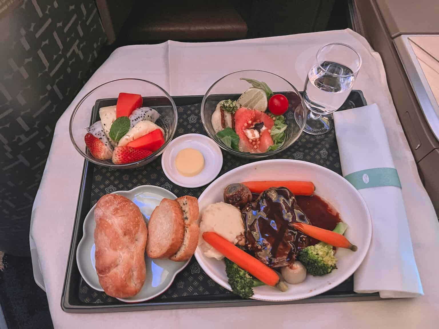Multi-course meal service on white china with bread, salad, main course and appetizers