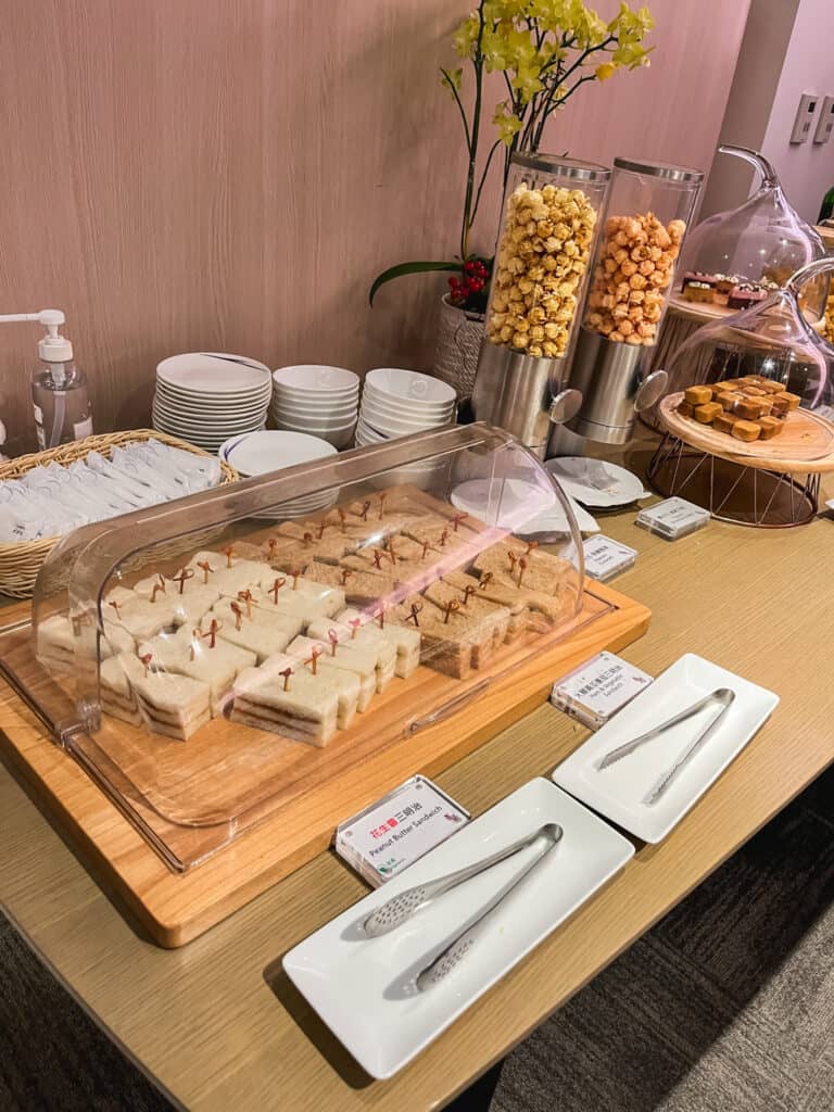 Taipei Airport lounge buffet spread featuring sandwiches, cereals, and continental breakfast items