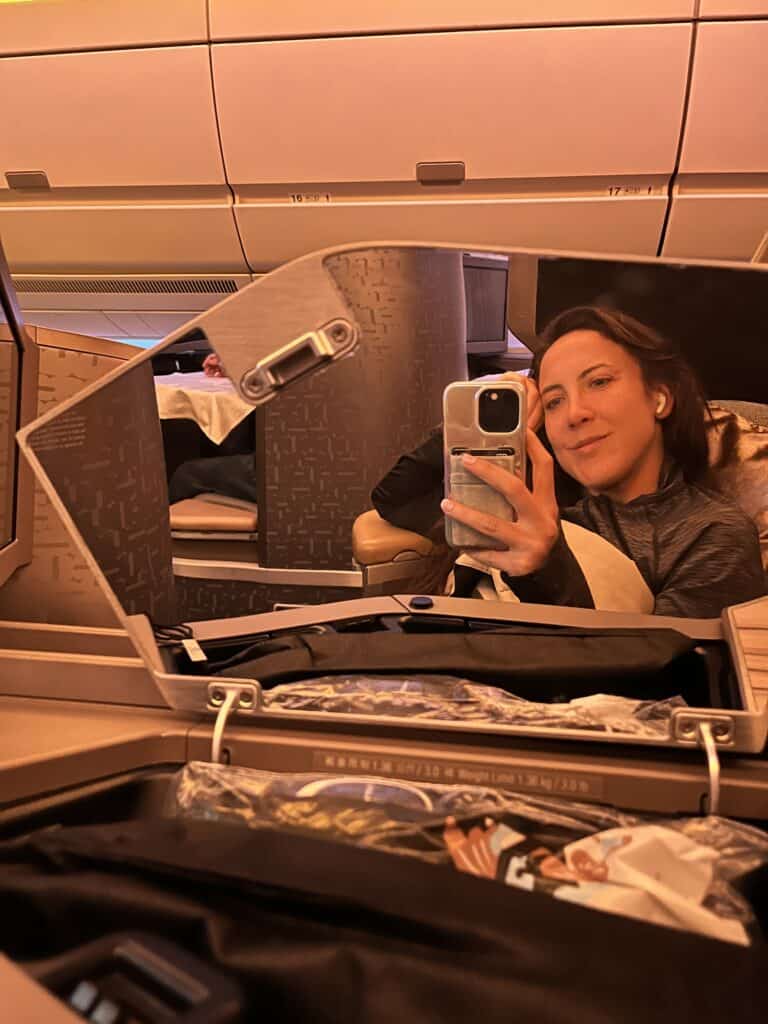 China Airlines business class passenger taking selfie in private suite with fold-down divider and premium seating