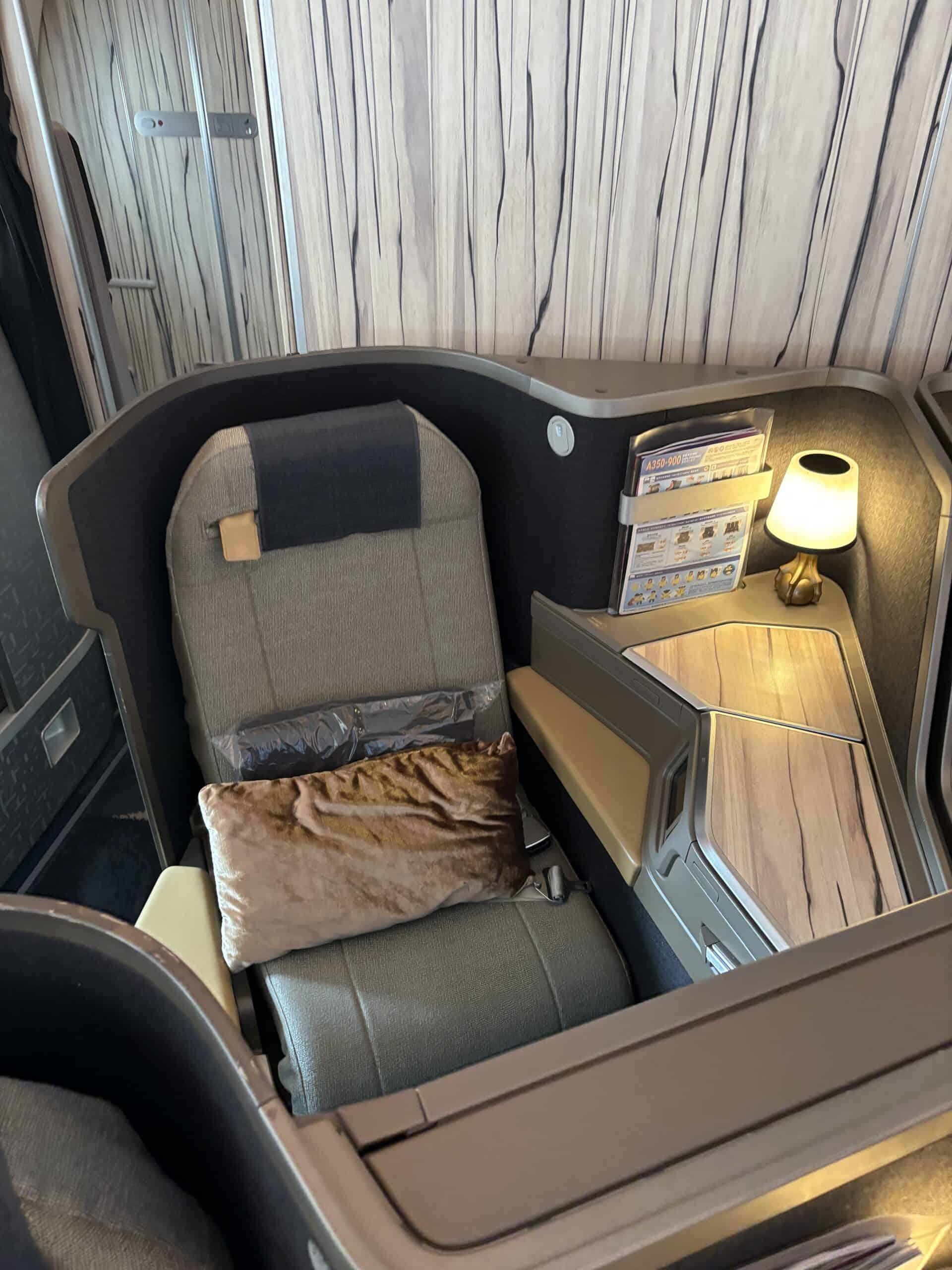 Individual business class suite with privacy divider, personal lamp and lie-flat seating