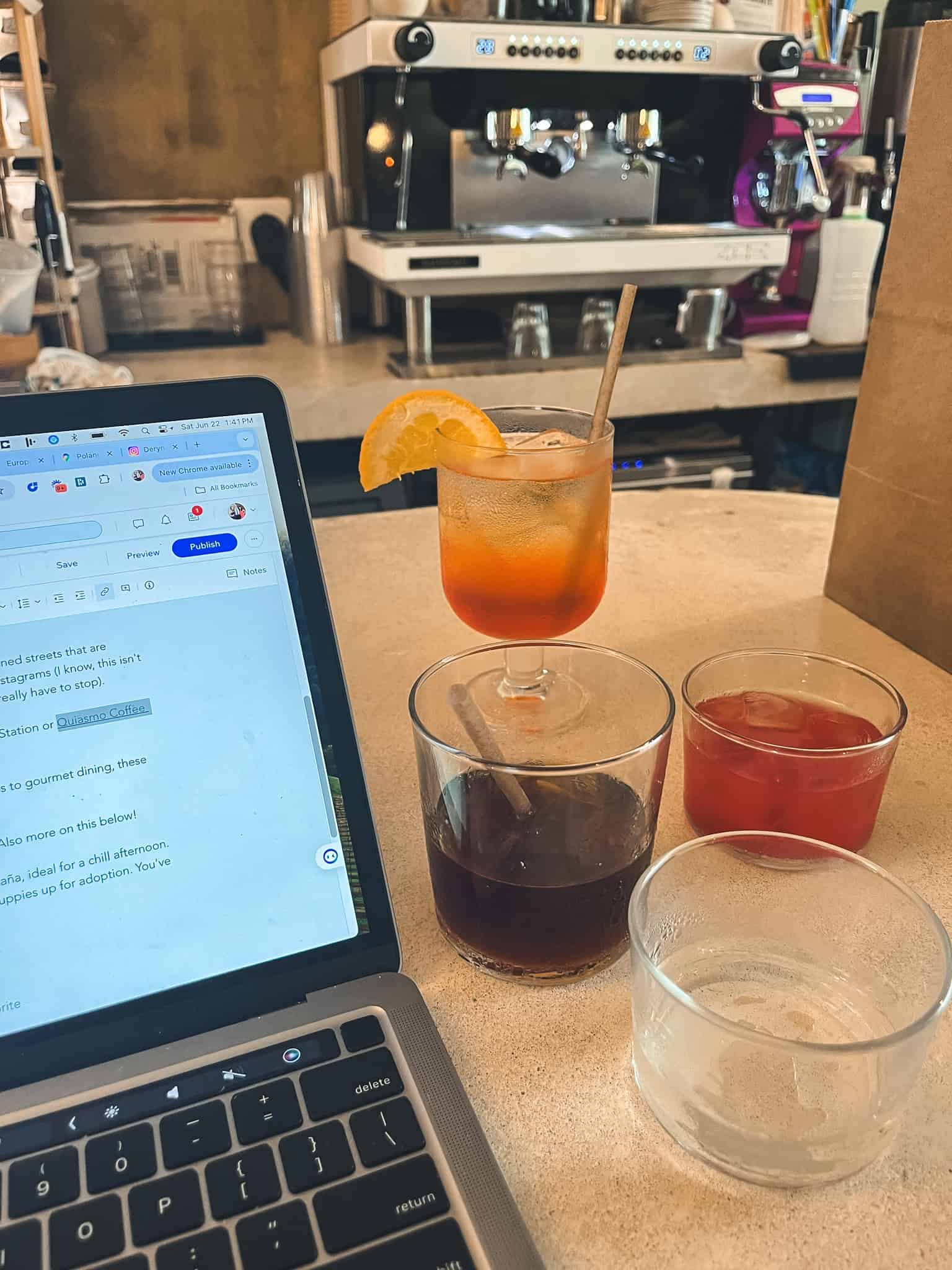 Digital nomad workspace setup with laptop and drinks, representing the remote work lifestyle that has contributed to Mexico City protests over housing displacement