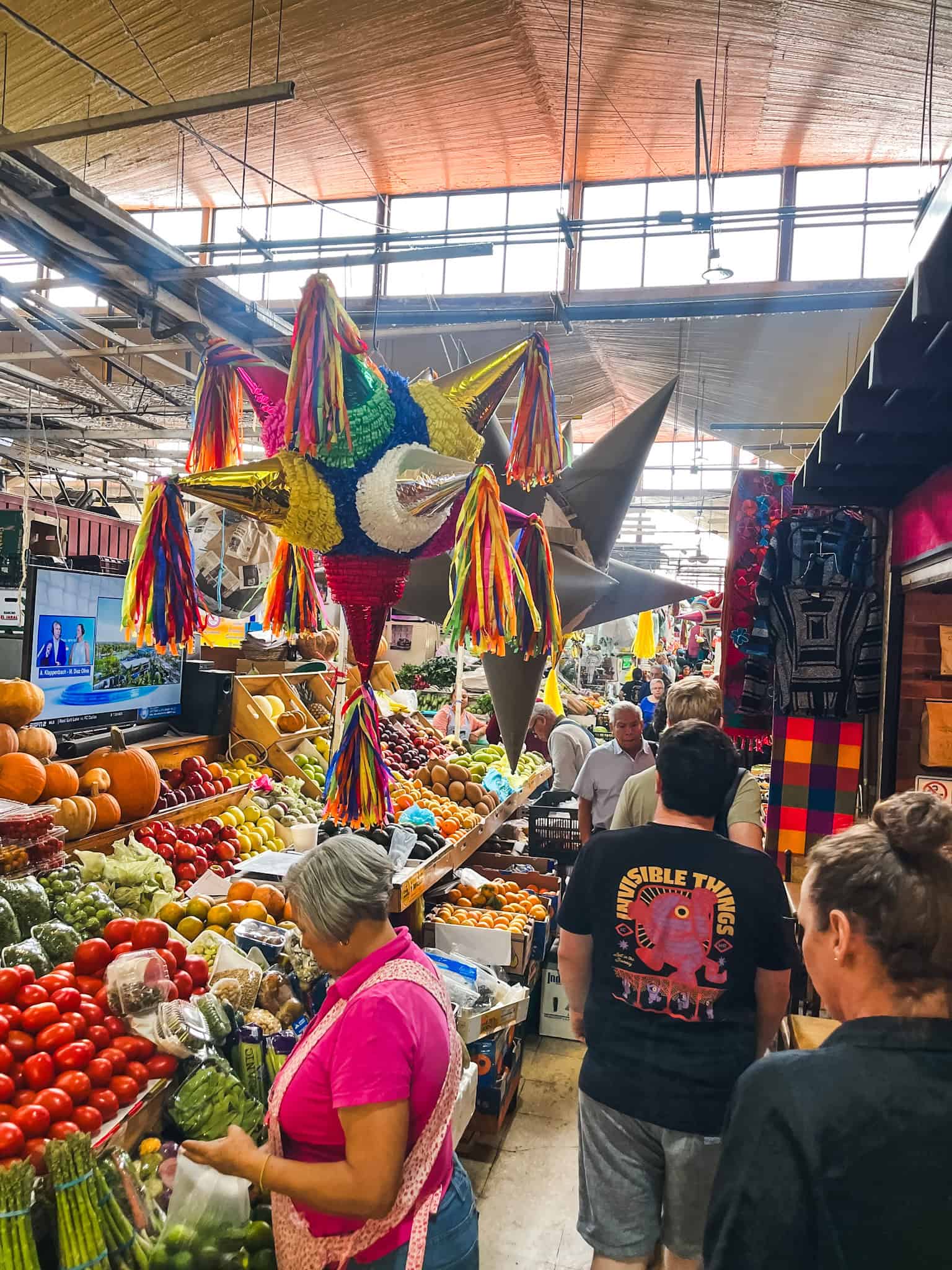 Traditional Mexican market with colorful piñatas and fresh produce displays, showcasing the local culture that Mexico City protesters want to preserve amid gentrification concerns