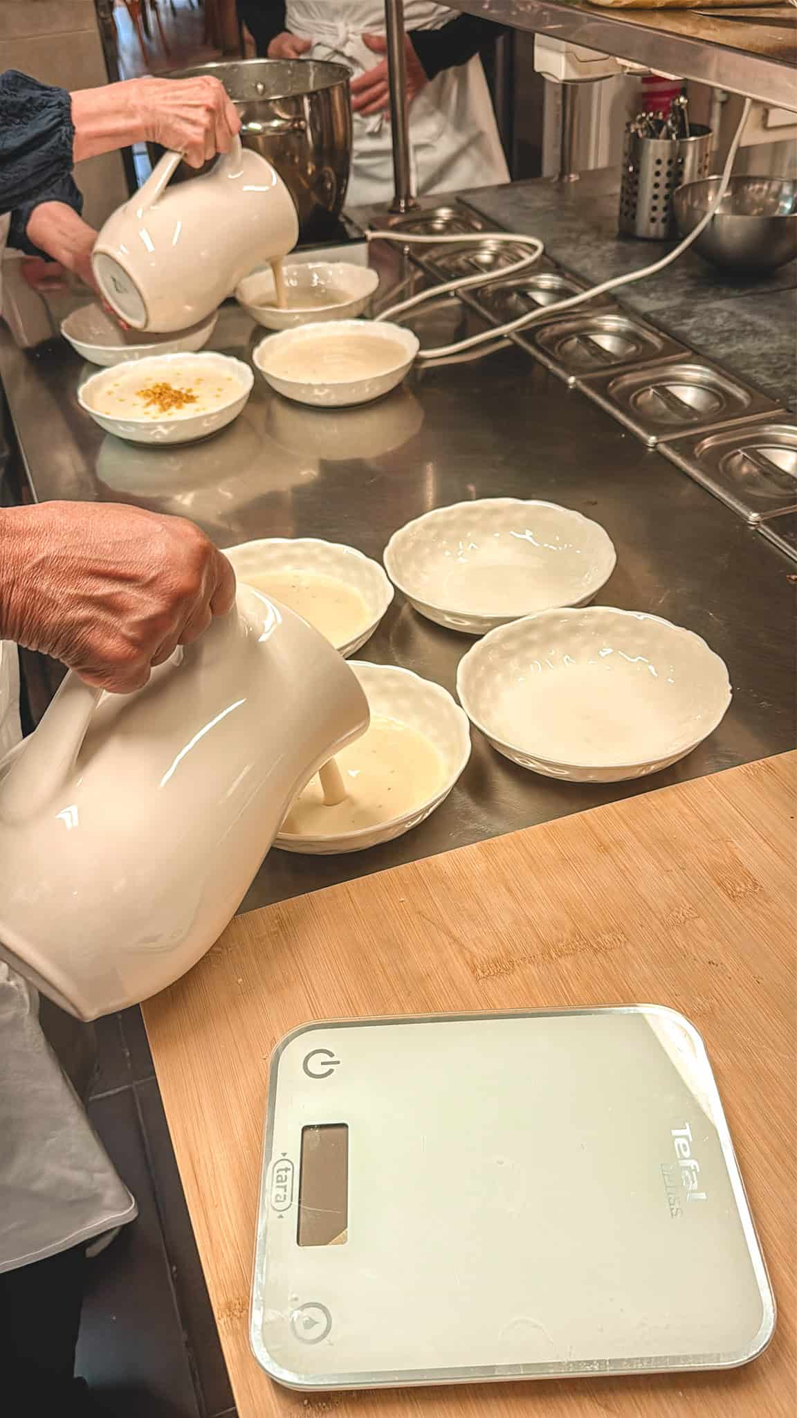 Pouring cream soup into bowls with precision at French culinary workshop