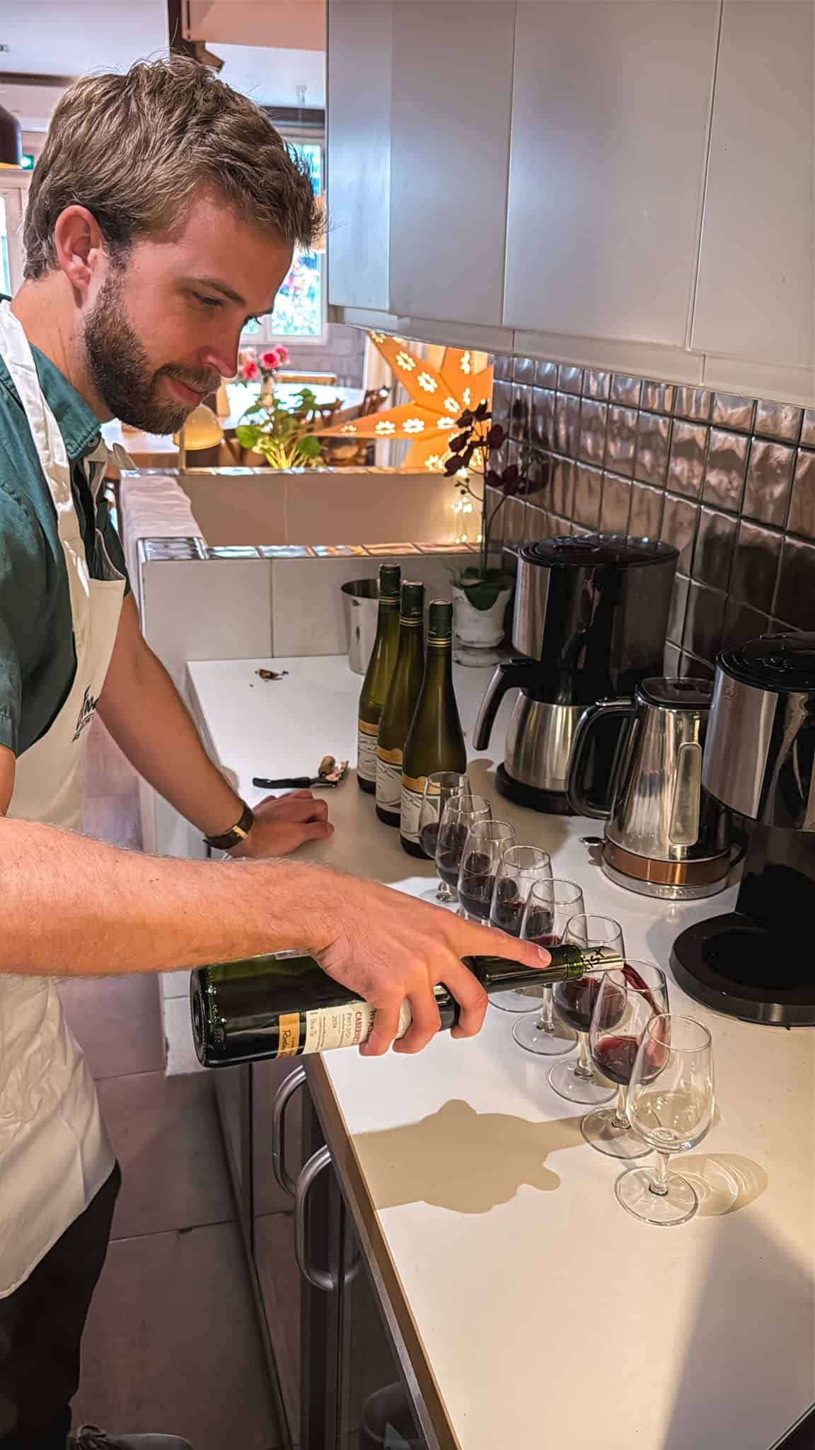 man pouring wine at cooking class in Paris