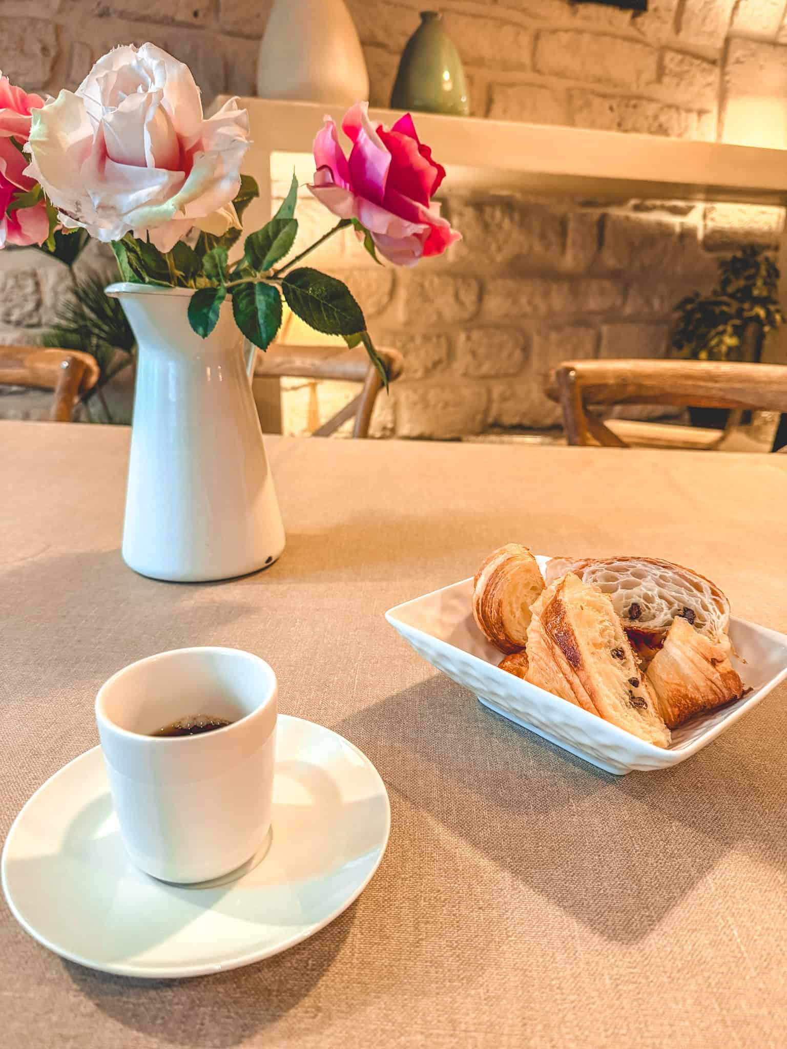 Classic French breakfast with espresso, croissants, and pain au chocolat with fresh roses
