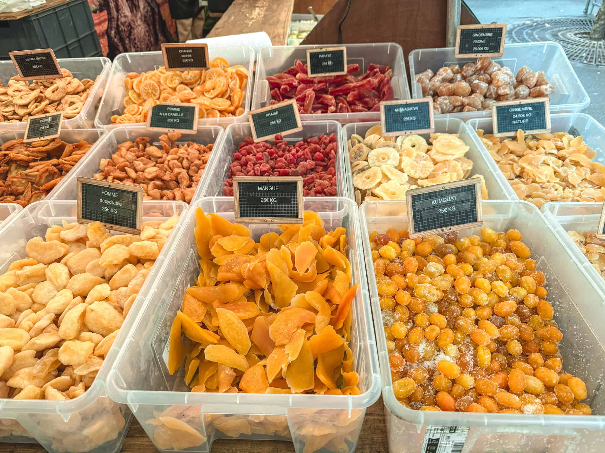 Dried fruits and candied treats at French market stall with price labels in euros