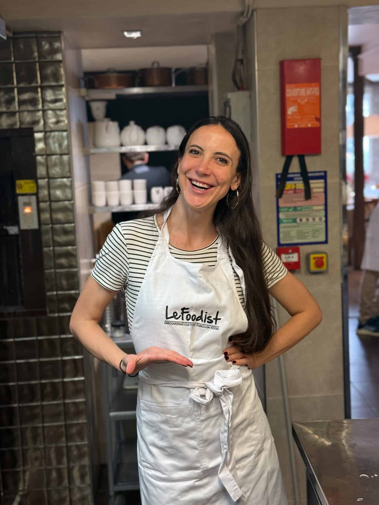 Happy participant wearing Le Foodist apron during cooking class in Paris