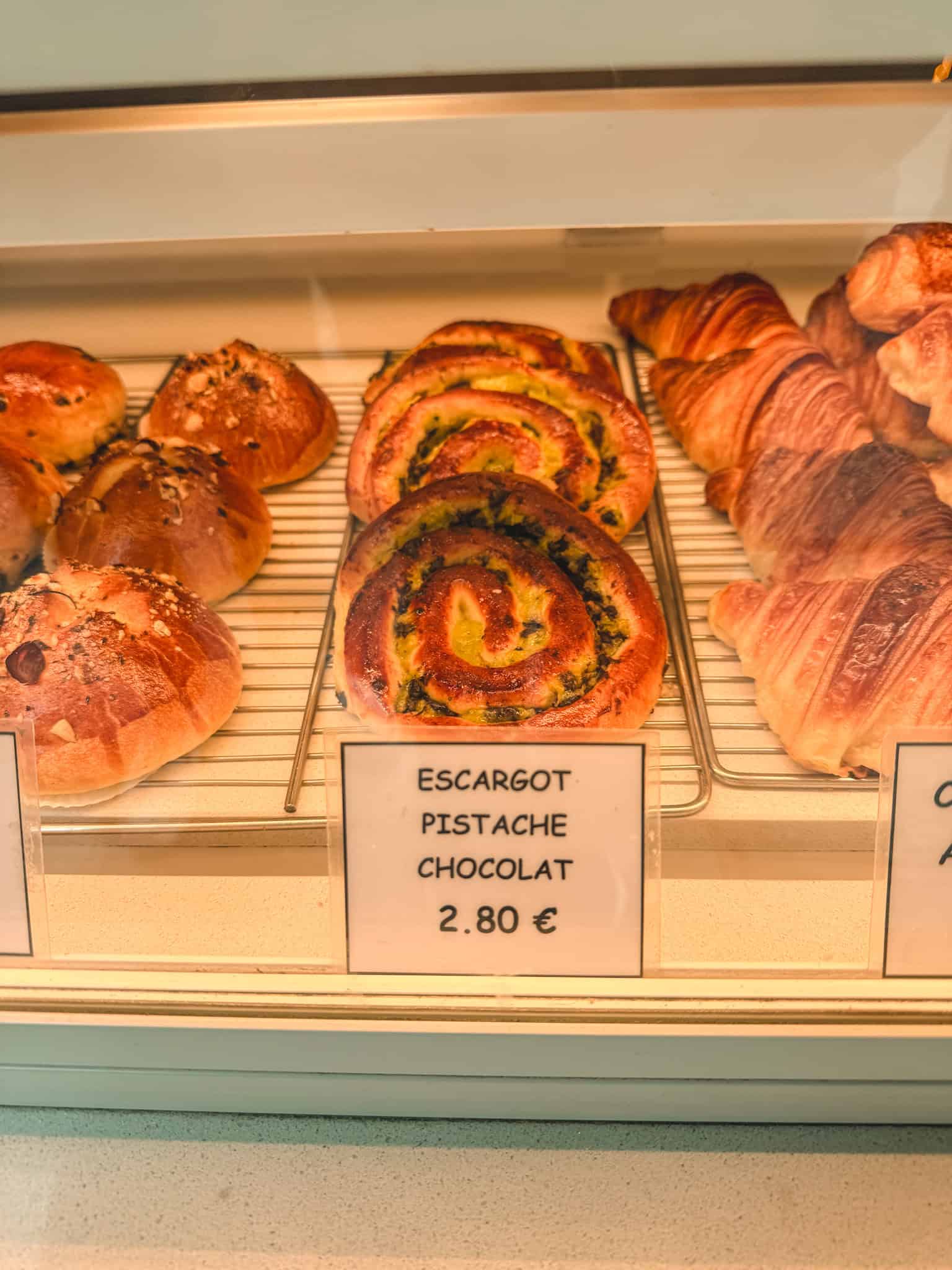 Escargot pistachio chocolate pastries at Parisian bakery displaying traditional must see things in Paris culinary specialties