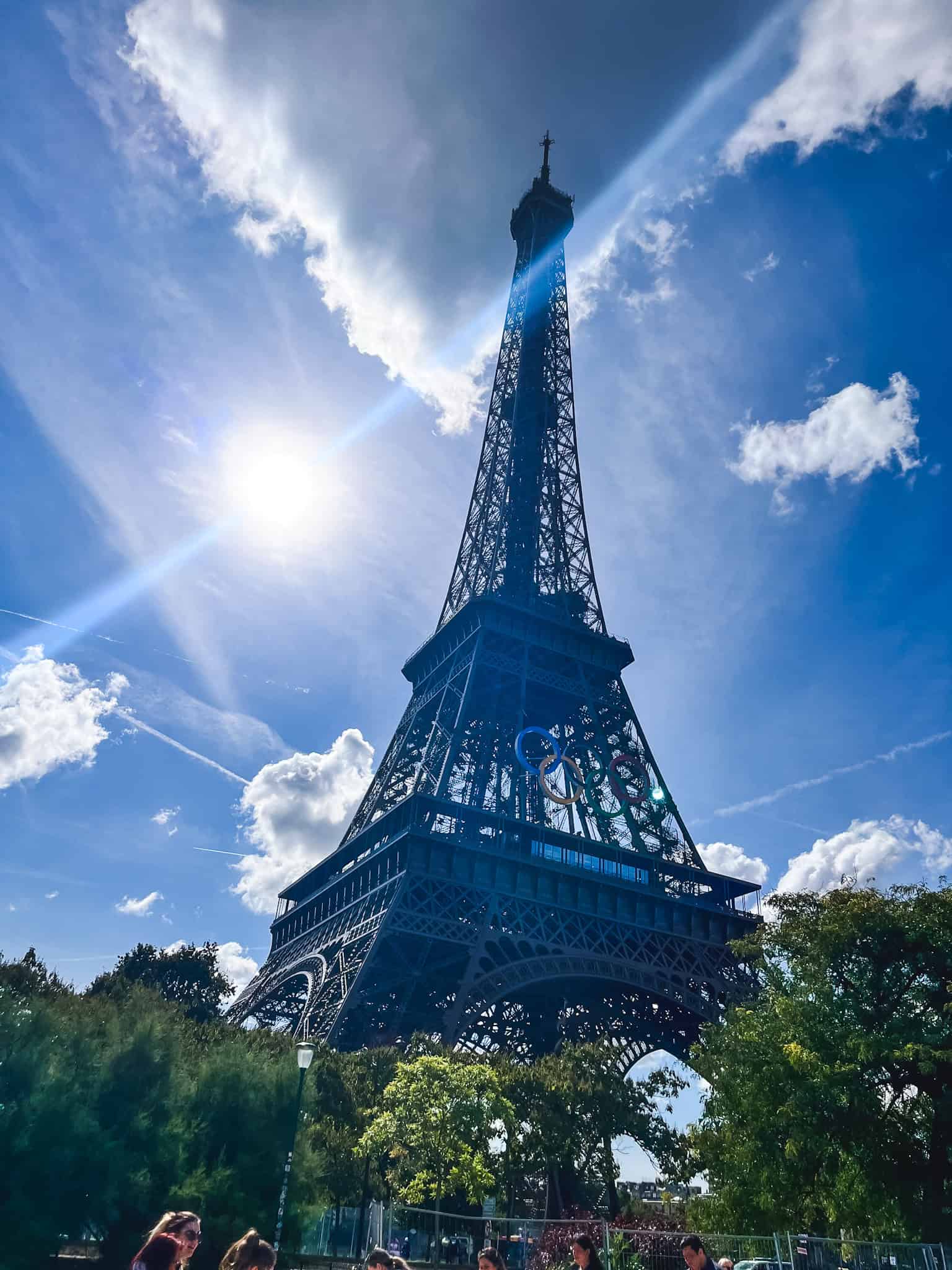 Eiffel Tower photographed during olympics from below against dramatic blue sky, iconic among things to do in Paris