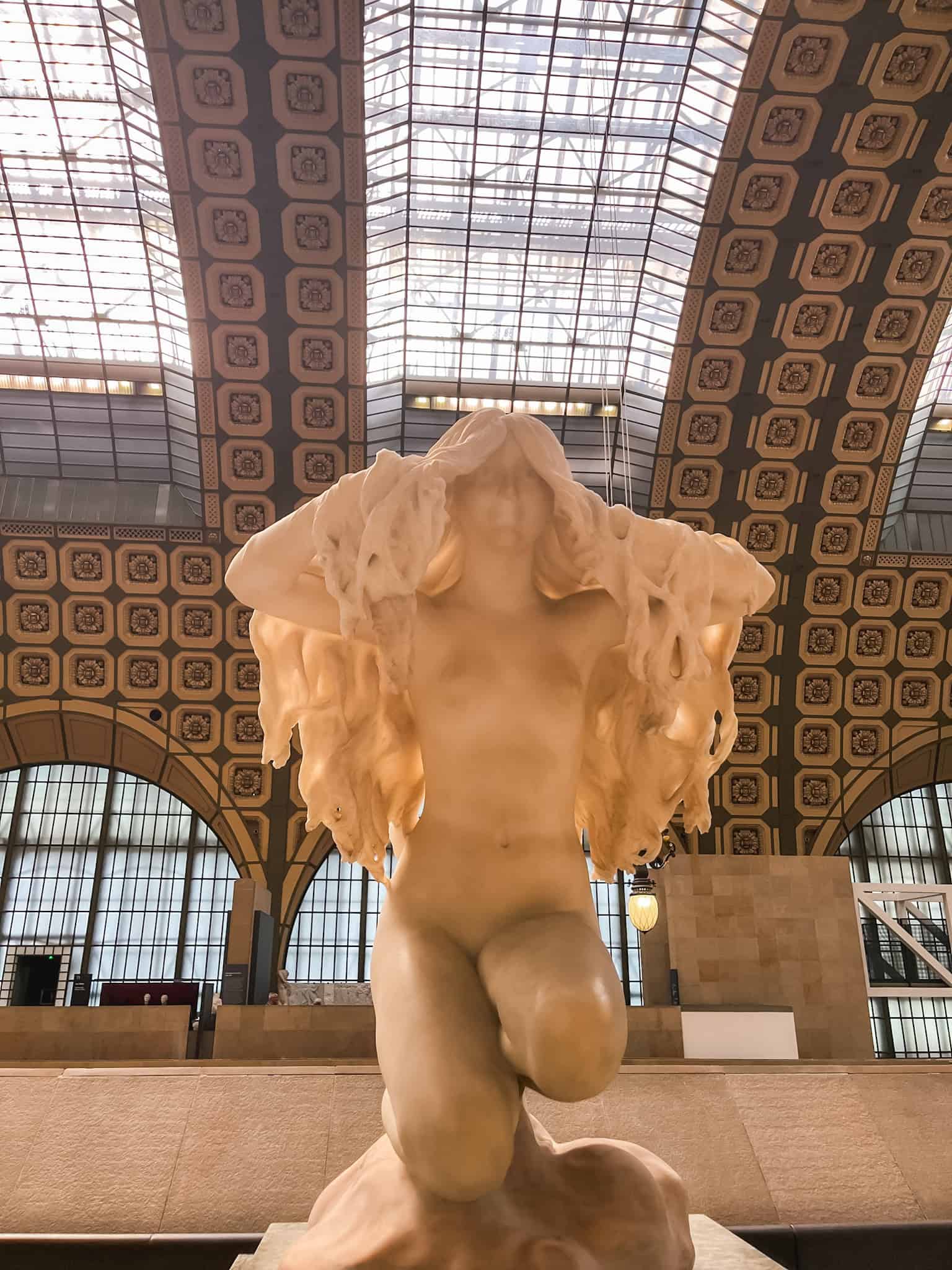 Classical marble statue in Musée d'Orsay's grand architecture, highlighting must see things in Paris world-class museum collections