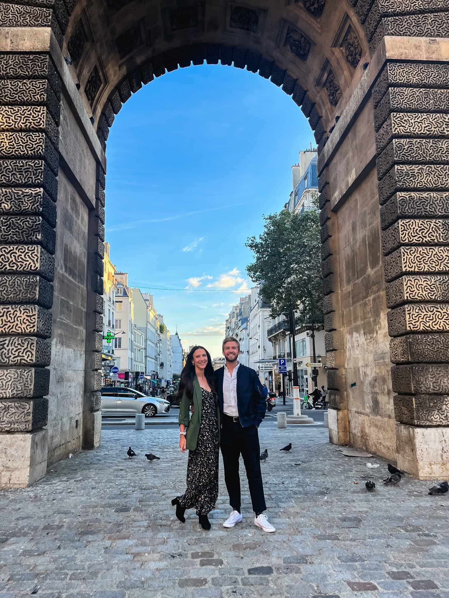 couple posing under arch in Paris