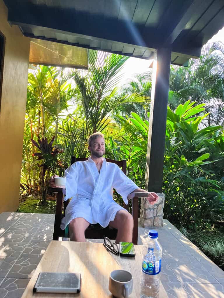 Guest relaxing in bathrobe on tropical terrace at Arenal Manoa Resort, showing luxury amenities where to stay in La Fortuna with jungle surroundings