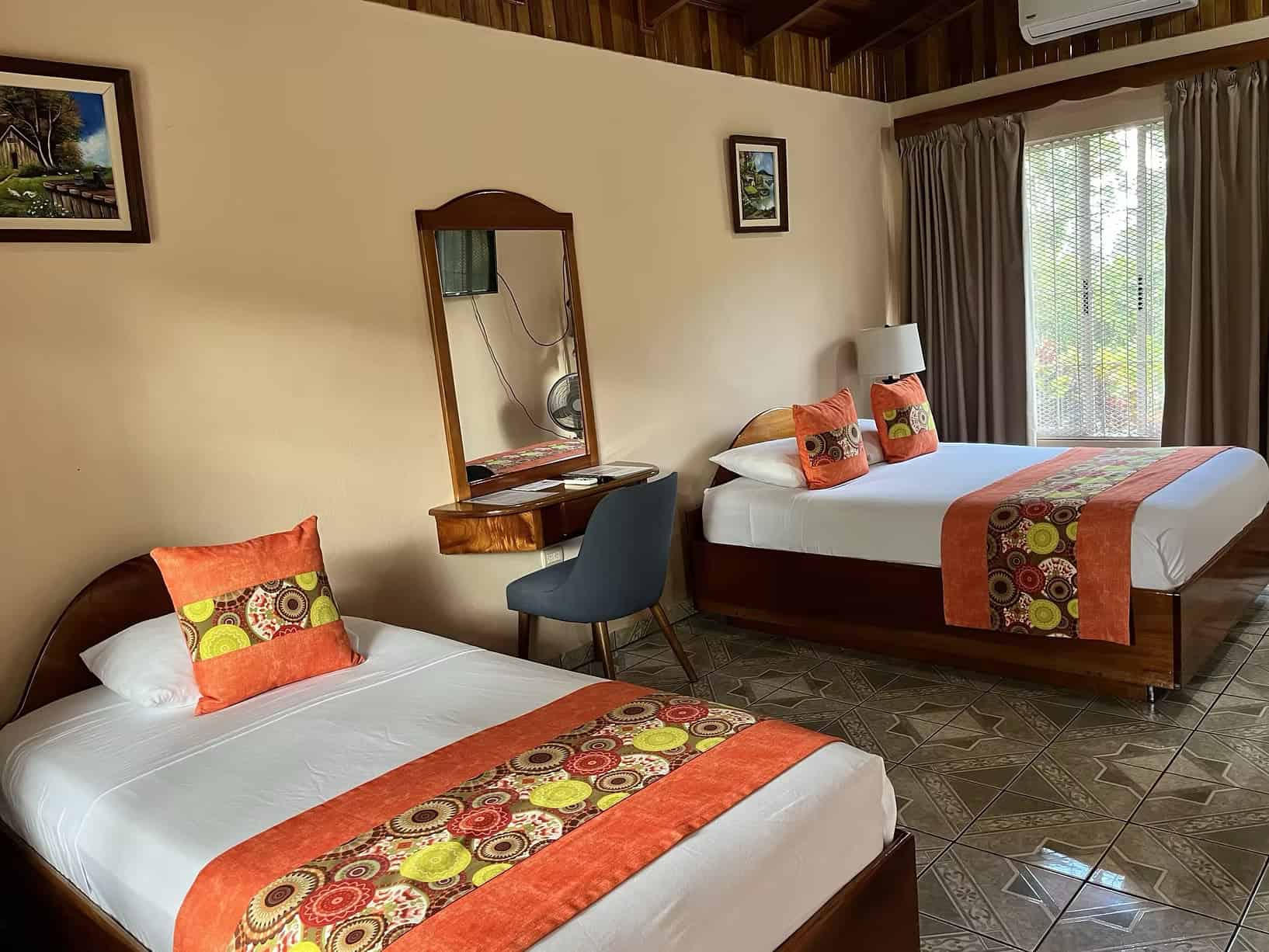 Hotel Villas Vilma room with twin beds and colorful decor showing where to stay in La Fortuna on a budget with comfortable accommodations