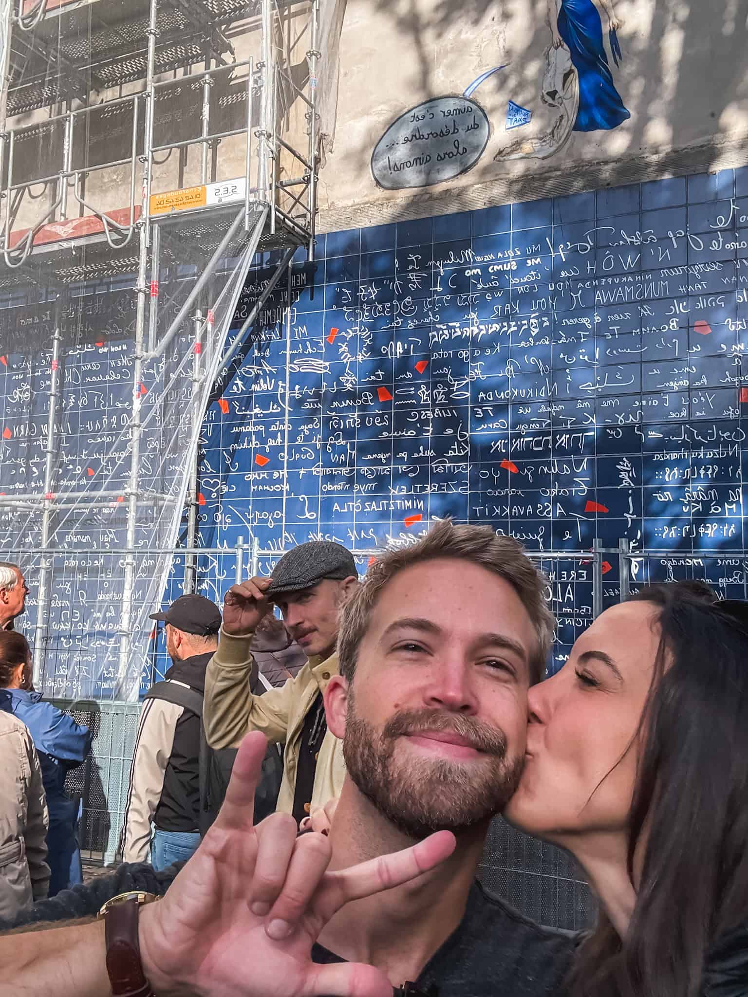couple kissing in front of the wall of i love yous in Paris