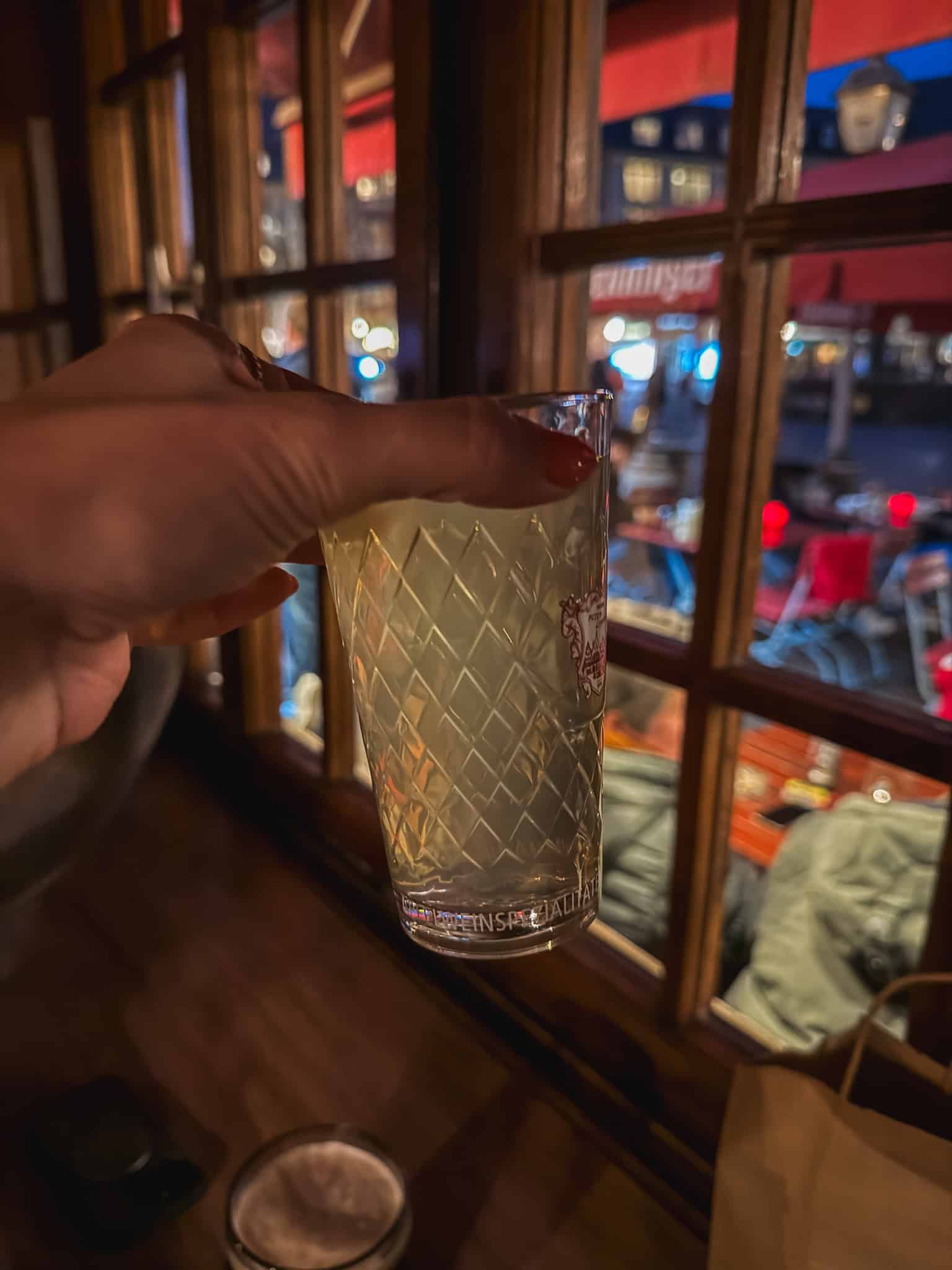 Traditional Apfelwein in classic Geripptes glass overlooking the street, authentic local drink for one day in FrankfurtRetry