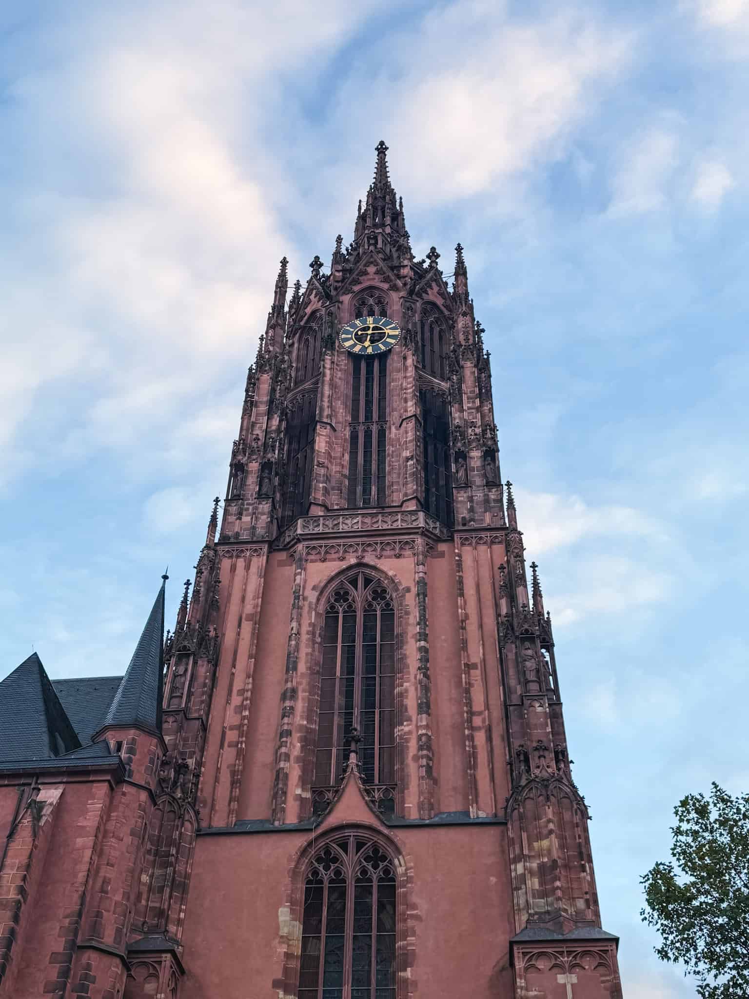 Frankfurt Cathedral's impressive Gothic tower reaching into the sky, iconic landmark to visit in Frankfurt