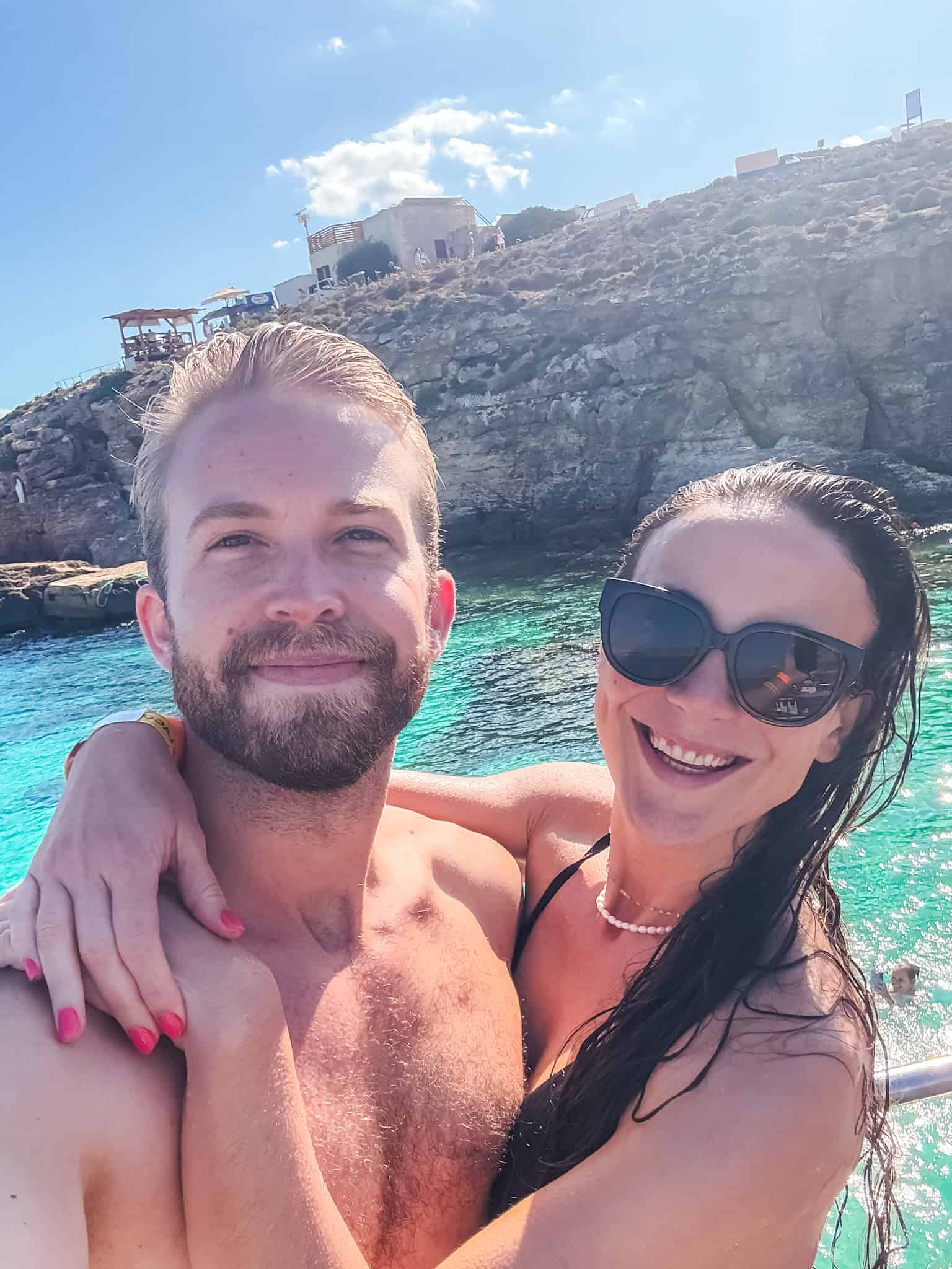 Couple on Malta boat tours exploring the Blue Lagoon with turquoise water on Comino