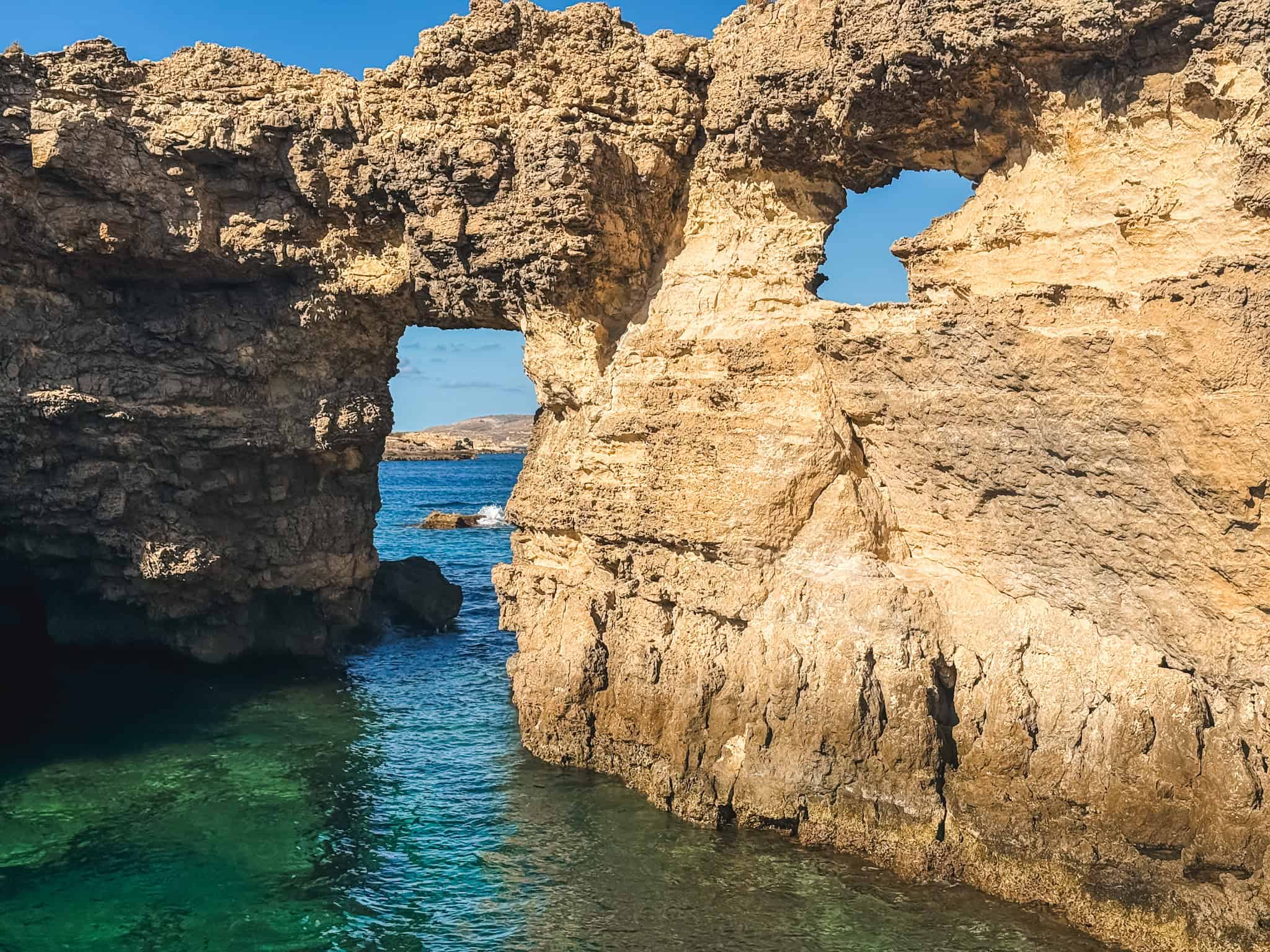 Natural limestone rock arches along Malta's coastline near the Crystal Lagoon