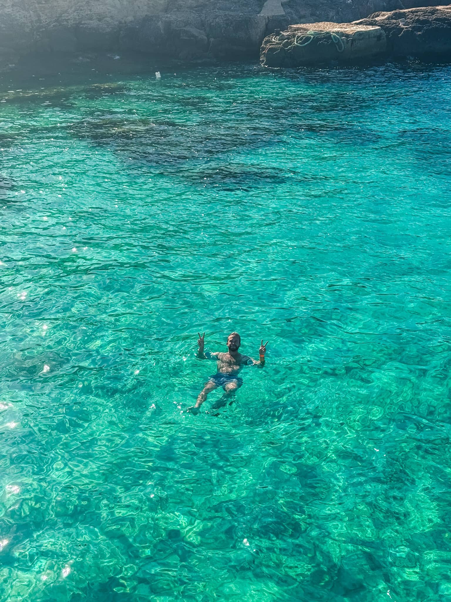 Swimming in the crystal lagoon waters near Comino caves on a Malta boat tour