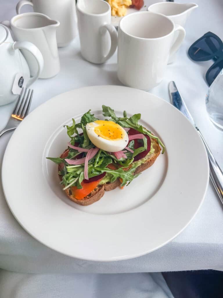 Smoked salmon avocado toast with arugula and soft boiled egg served during GoldLeaf breakfast service in Canadian Rockies