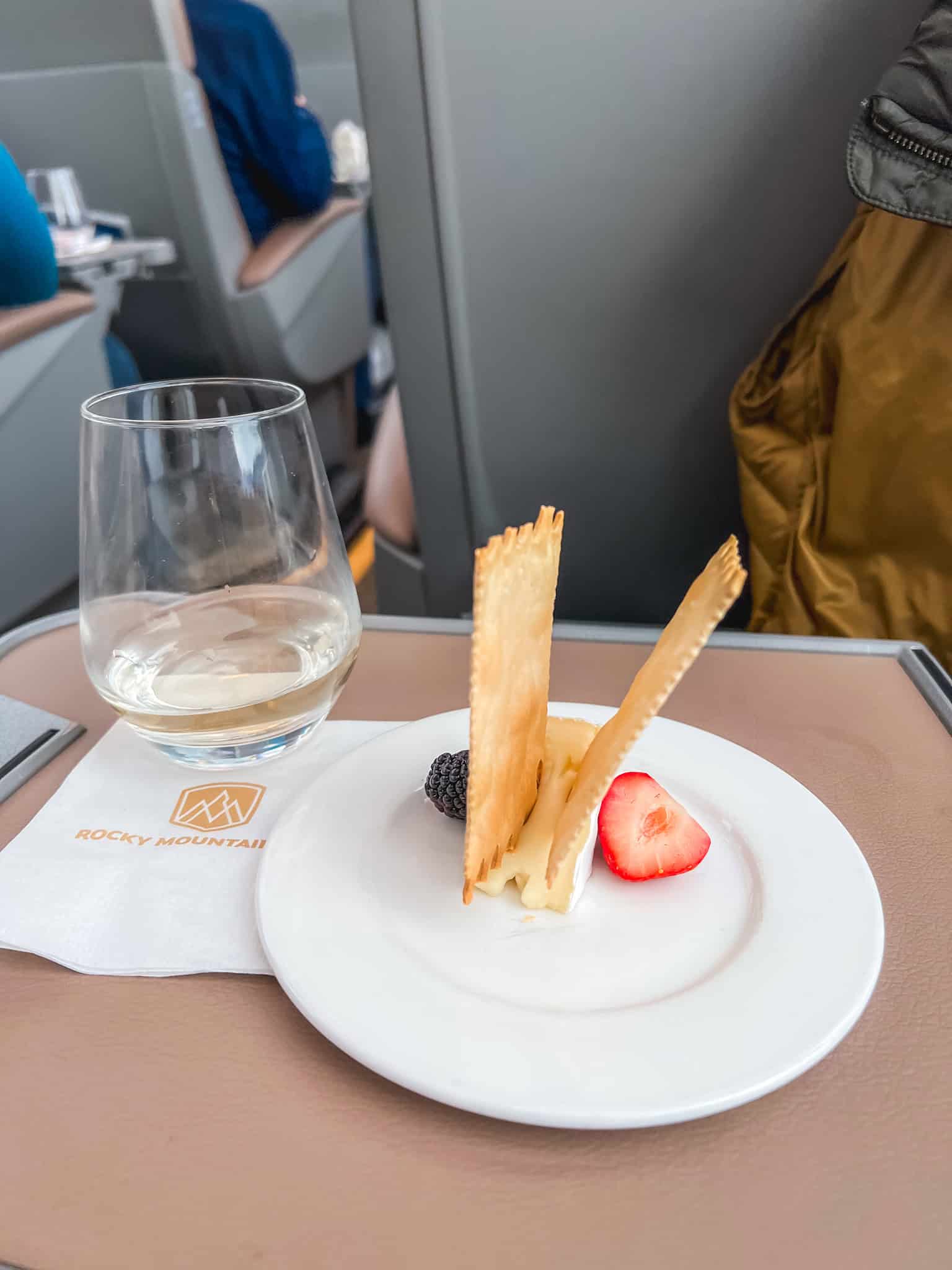 Artisan cheese plate with phyllo crisps, berries, and wine served as dessert on Rocky Mountaineer train GoldLeaf service
