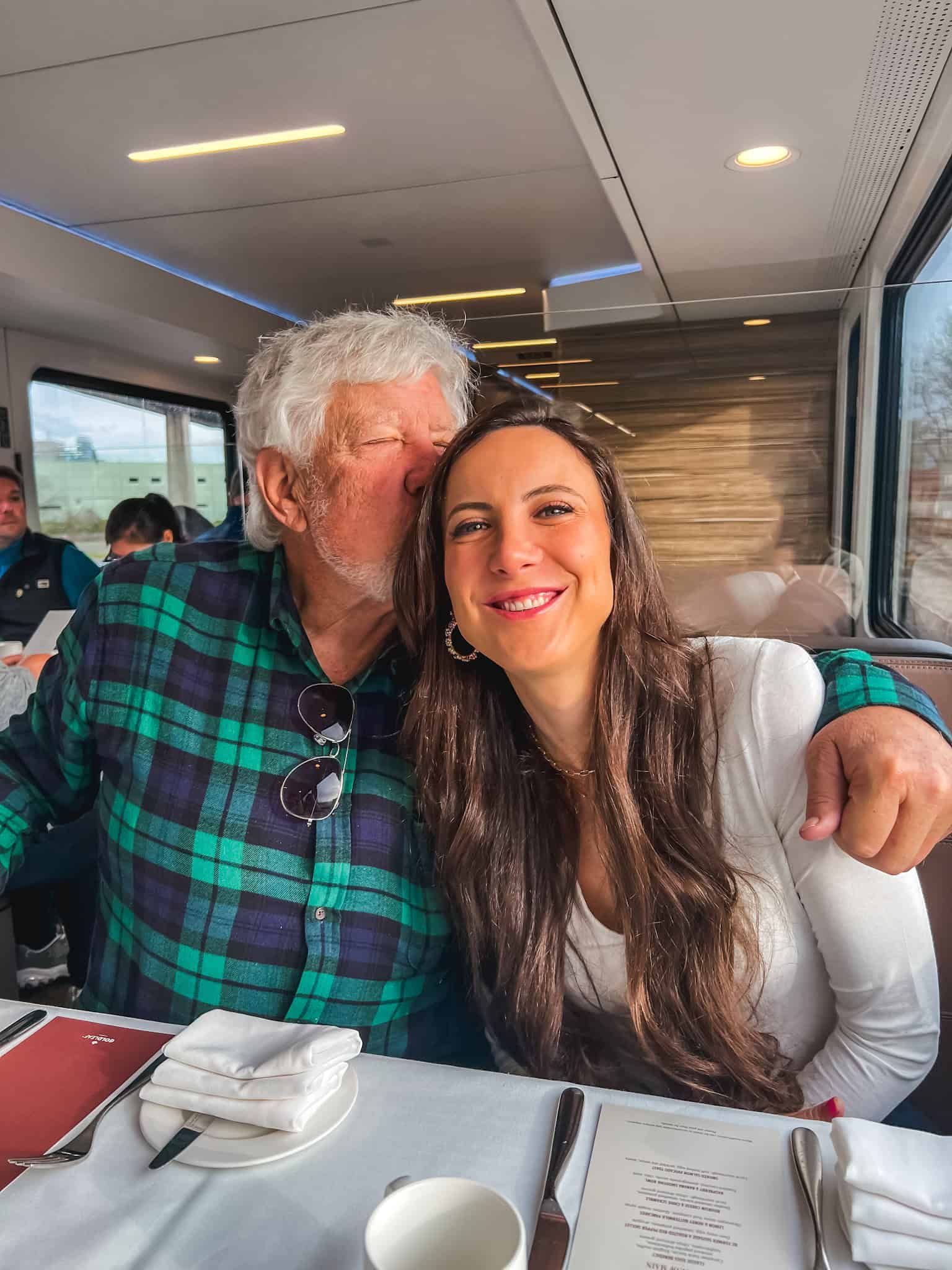 Passengers dining in Rocky Mountaineer train GoldLeaf dining car with panoramic windows during scenic Canadian Rockies journey
