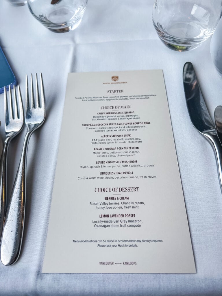 Lunch menu featuring BC steelhead, Alberta striploin steak, and Dungeness crab ravioli on Vancouver to Kamloops route