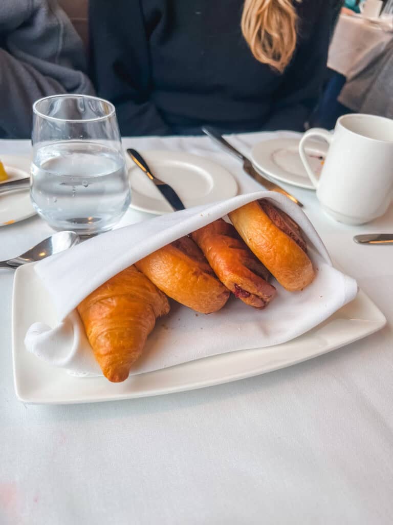 Fresh baked croissants and pain au chocolat served in basket during luxury train breakfast service through Canadian Rockies