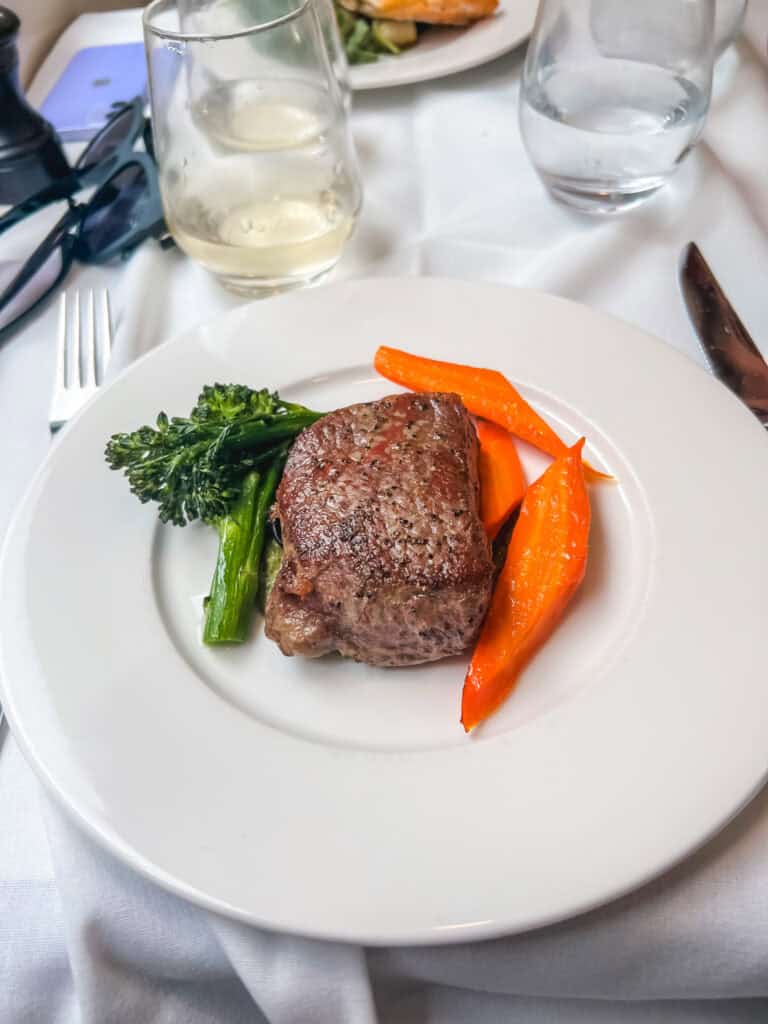 Rocky Mountaineer train Alberta striploin steak with broccolini and glazed carrots plated for gourmet lunch service