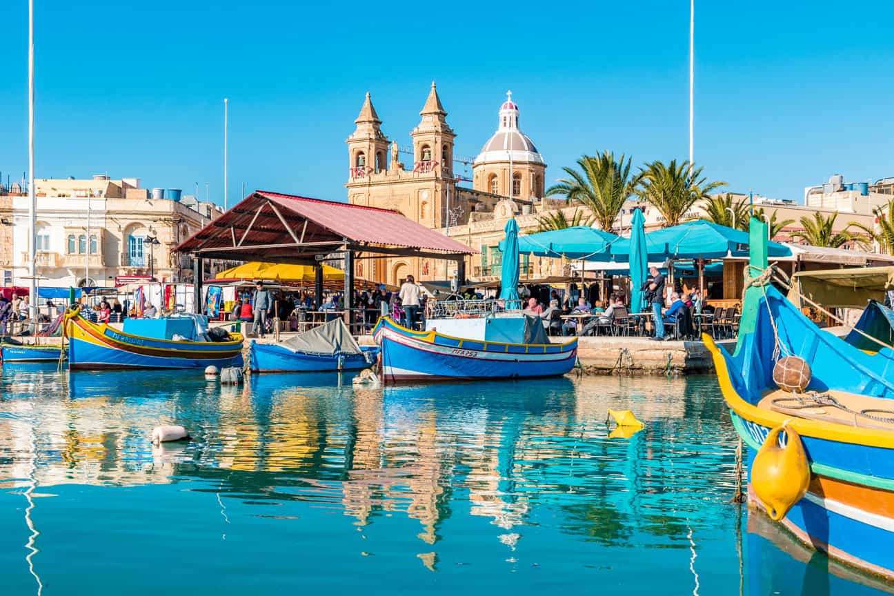 Marsaxlokk fishing village with colorful luzzu boats and waterfront restaurants Malta day trip