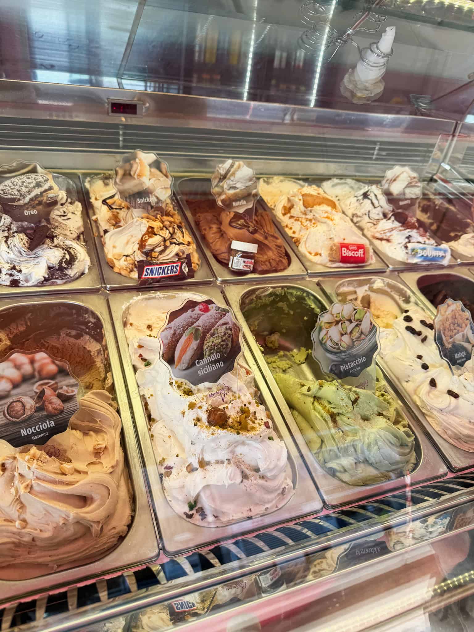Artisan gelato display with Italian flavors including pistachio and cannoli Siciliano Malta desserts
