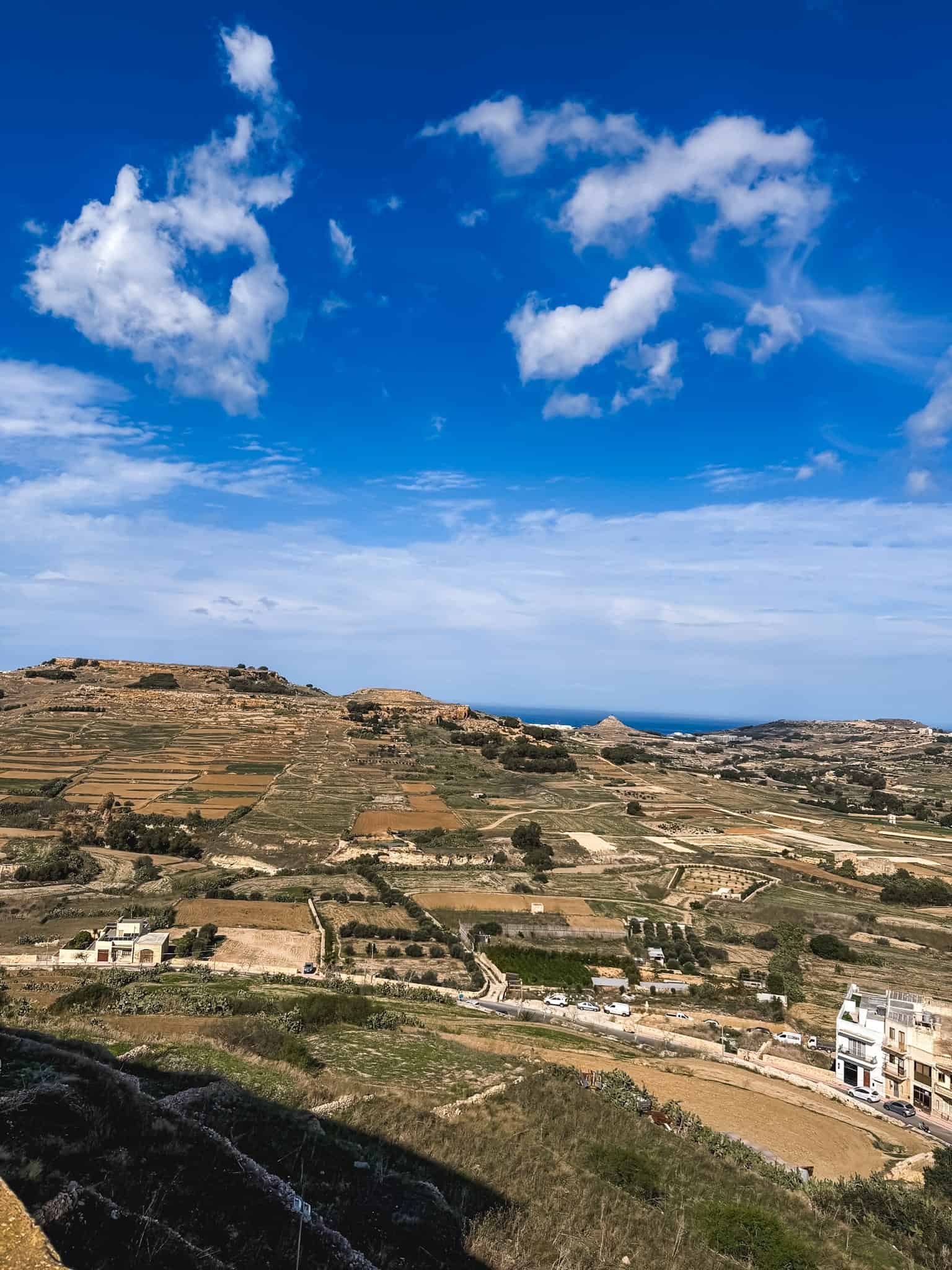 Scenic Gozo countryside with terraced farmland and coastal views during one week in Malta island hopping