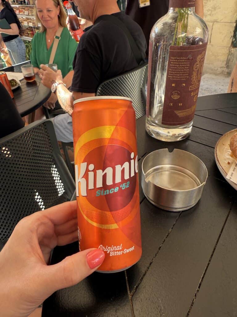 trying bitter kinnie soda on a food tour in malta