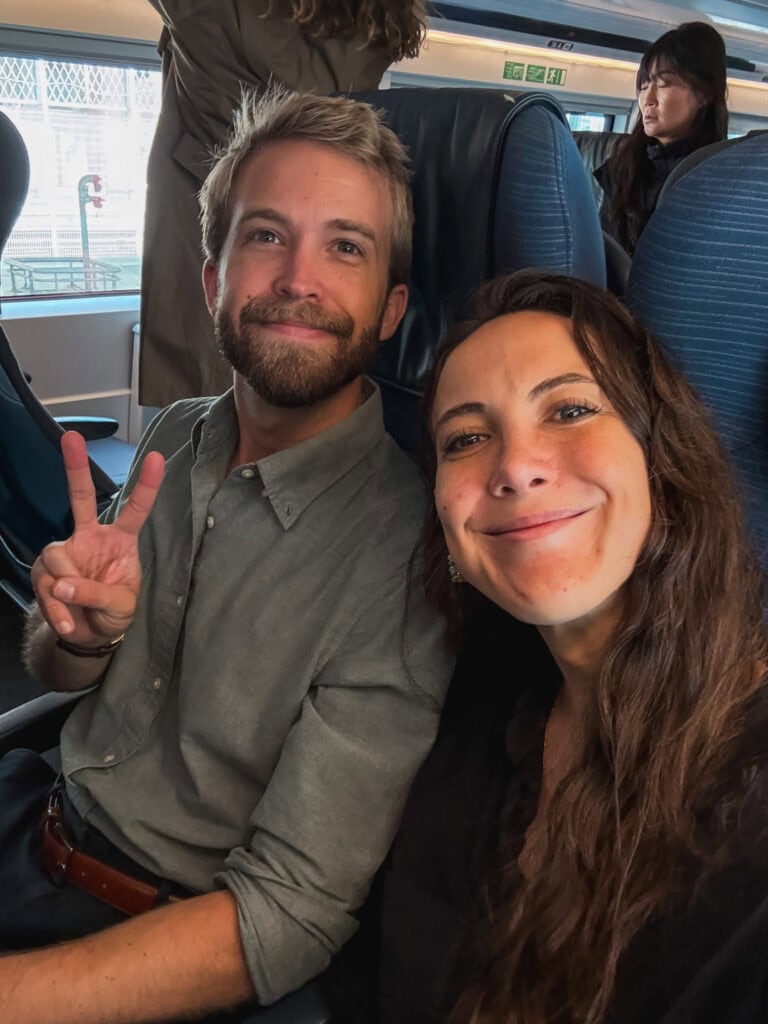 A happy couple taking a selfie seated together in their Eurostar cabin while on the train from paris to london through the Channel Tunnel