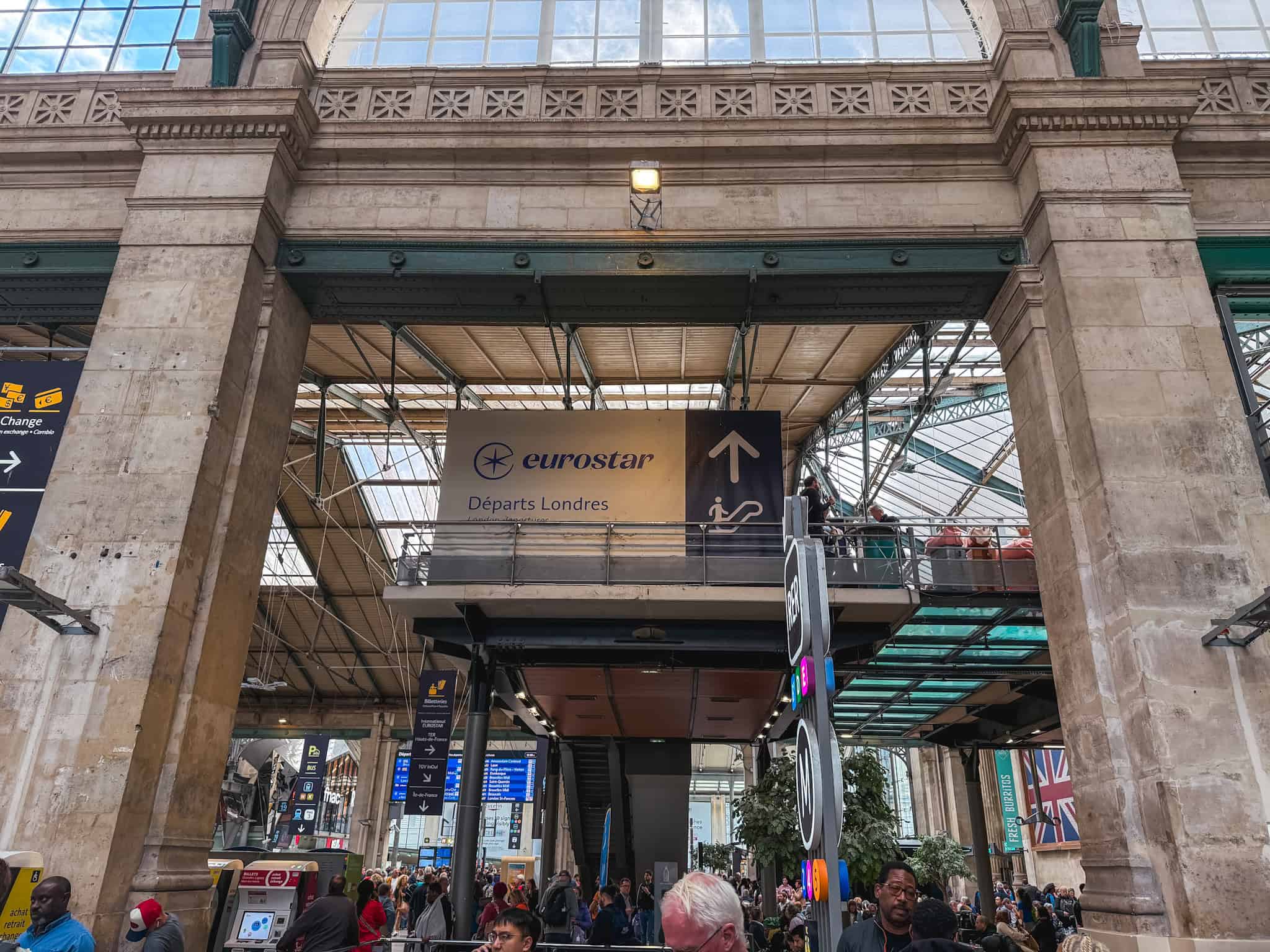 Eurostar London departures sign inside Gare du Nord station guiding travelers through the grand historic Paris terminal